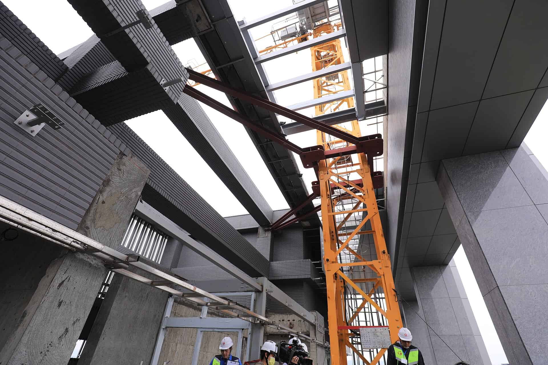 Workers and a tower crane at a building construction site