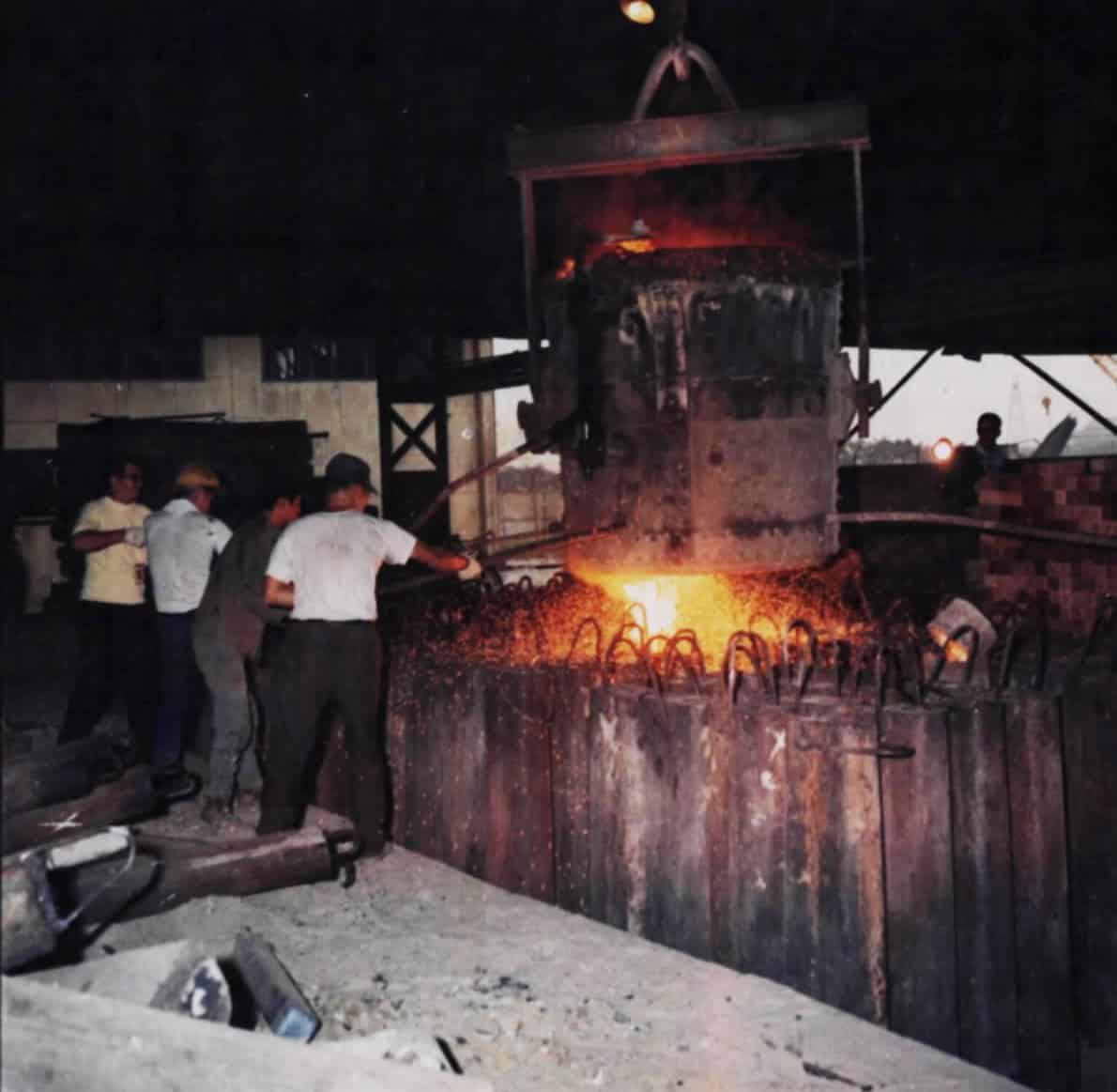 Steelworkers pour molten steel at a steel mill