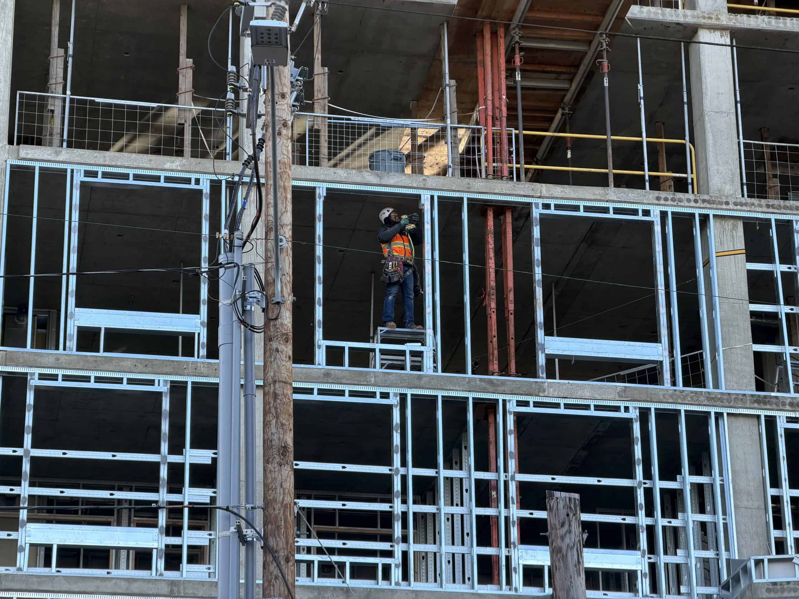 A construction worker on structural steel framing at a transit center in Portland, Oregon