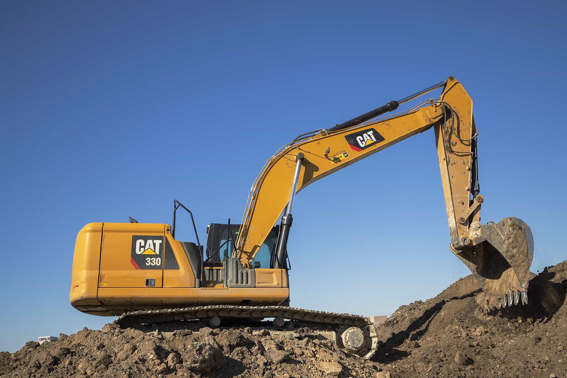 A Caterpillar 330 hydraulic excavator working a pile of dirt