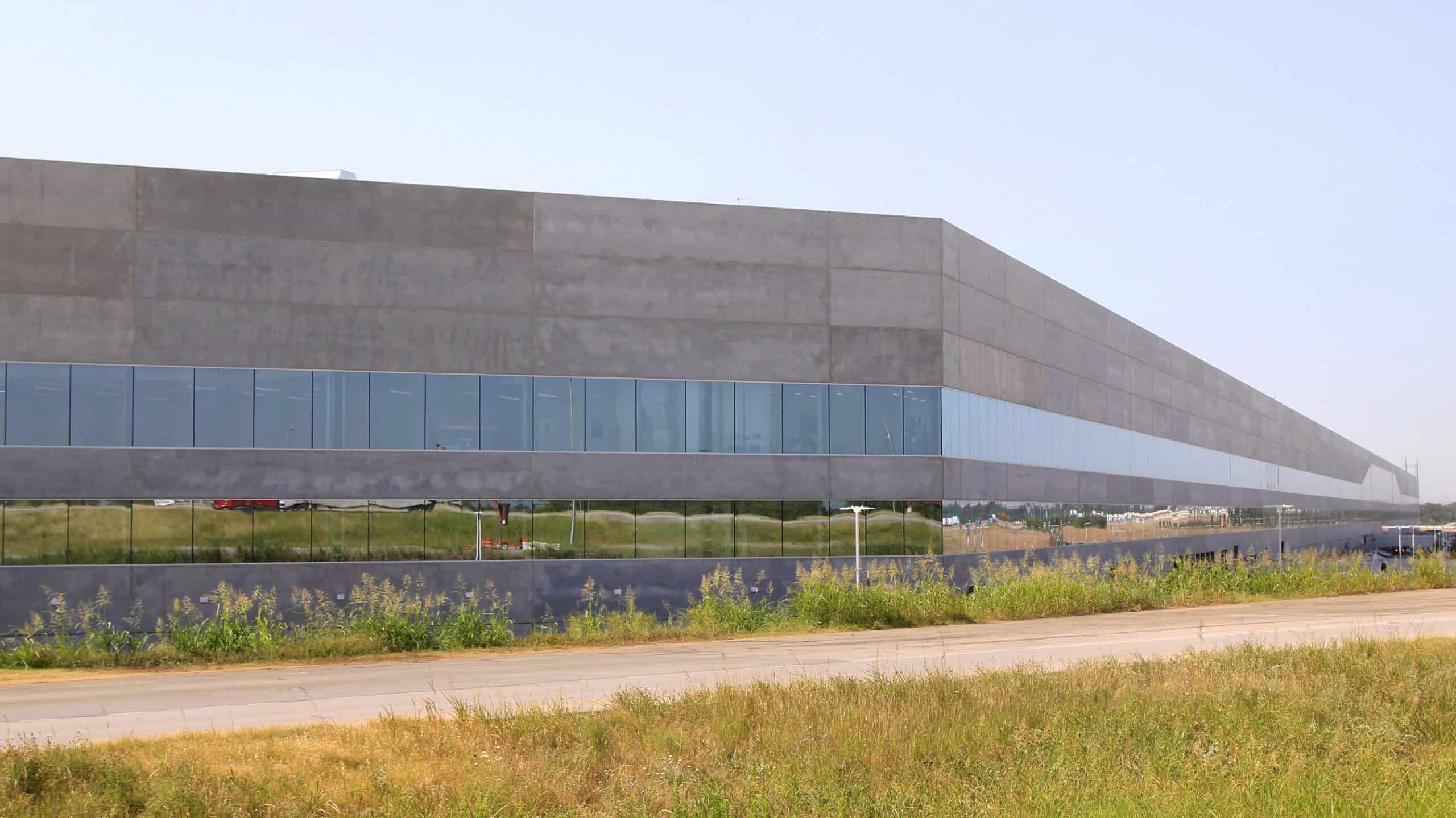 Tesla Gigafactory Texas Building 1 in Austin, a long factory under a clear sky