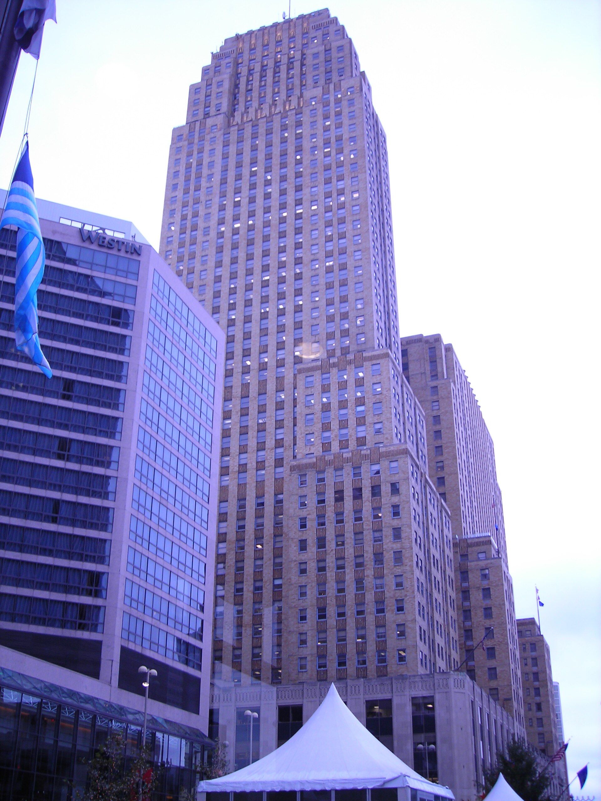 Projects Carew Tower rising above downtown Cincinnati at dusk