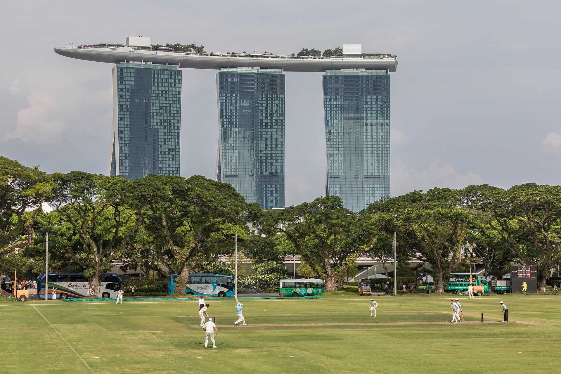 The three Marina Bay Sands hotel towers and SkyPark seen across a cricket field in Singapore
