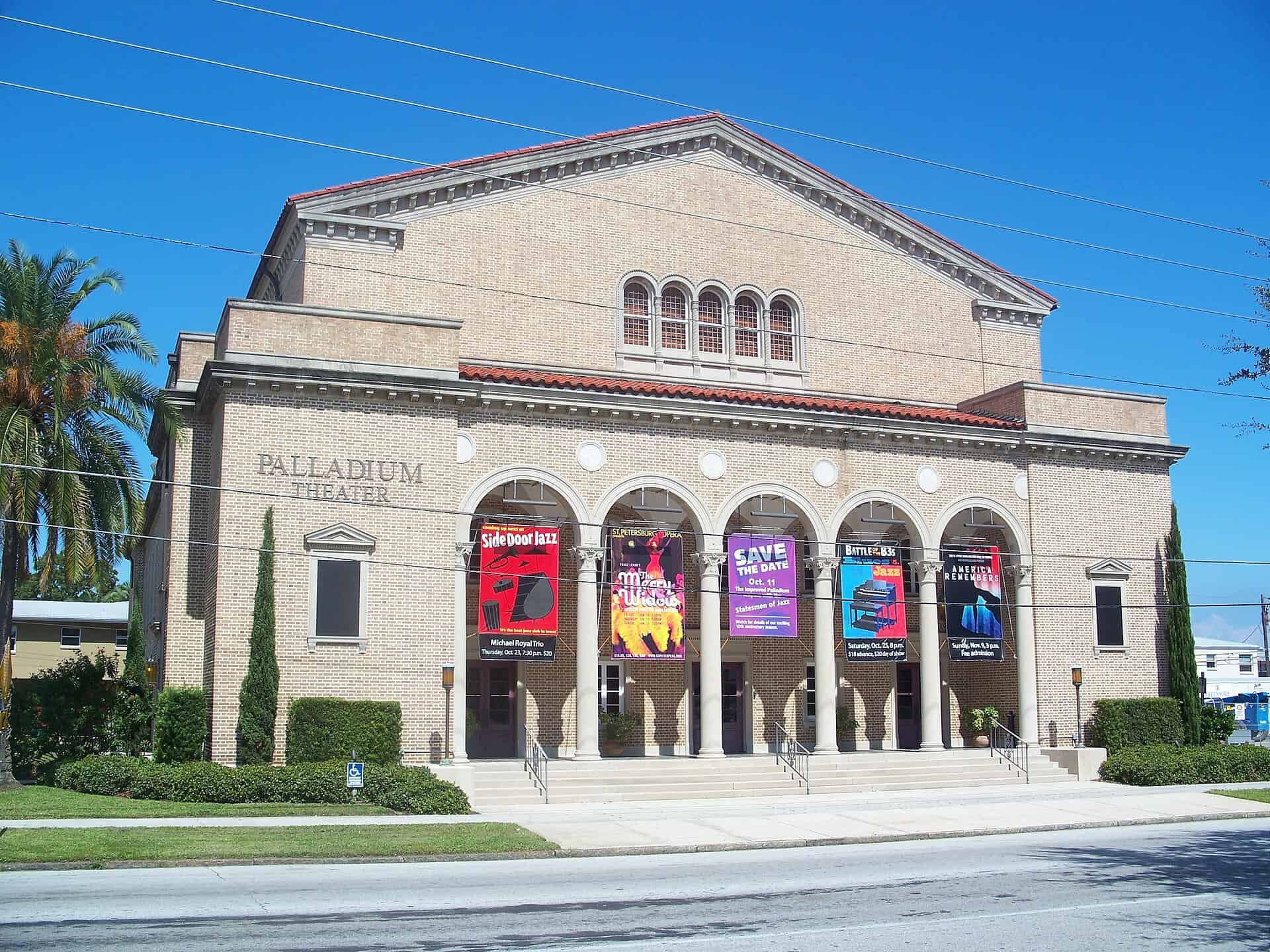 Classical stone facade of the Palladium Theater in St. Petersburg with arcaded entrance and show banners