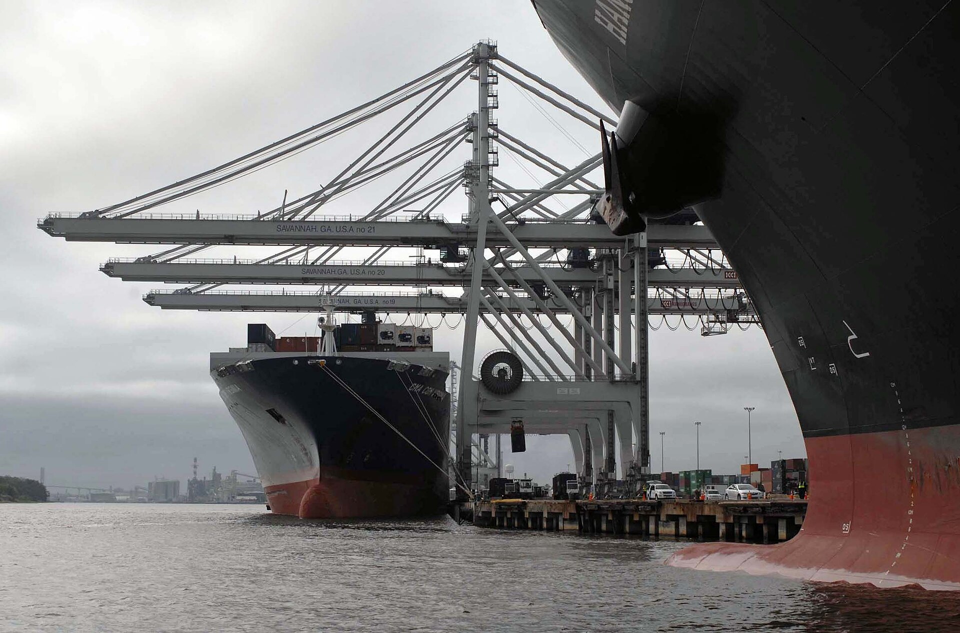 Aerial view of container cranes, stacked containers and a berthed vessel at Savannah Harbor