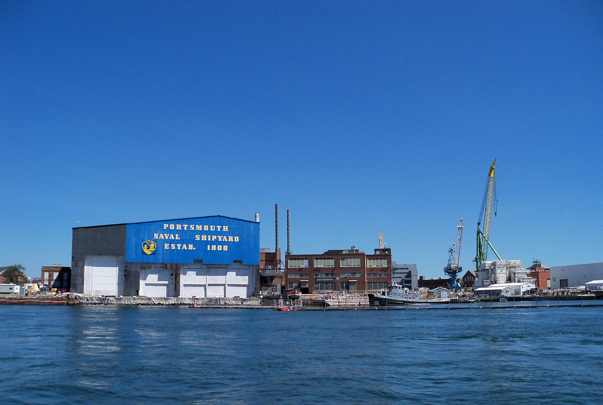 Portsmouth Naval Shipyard on Seavey Island seen from the Piscataqua River, with dry dock cranes along the waterfront