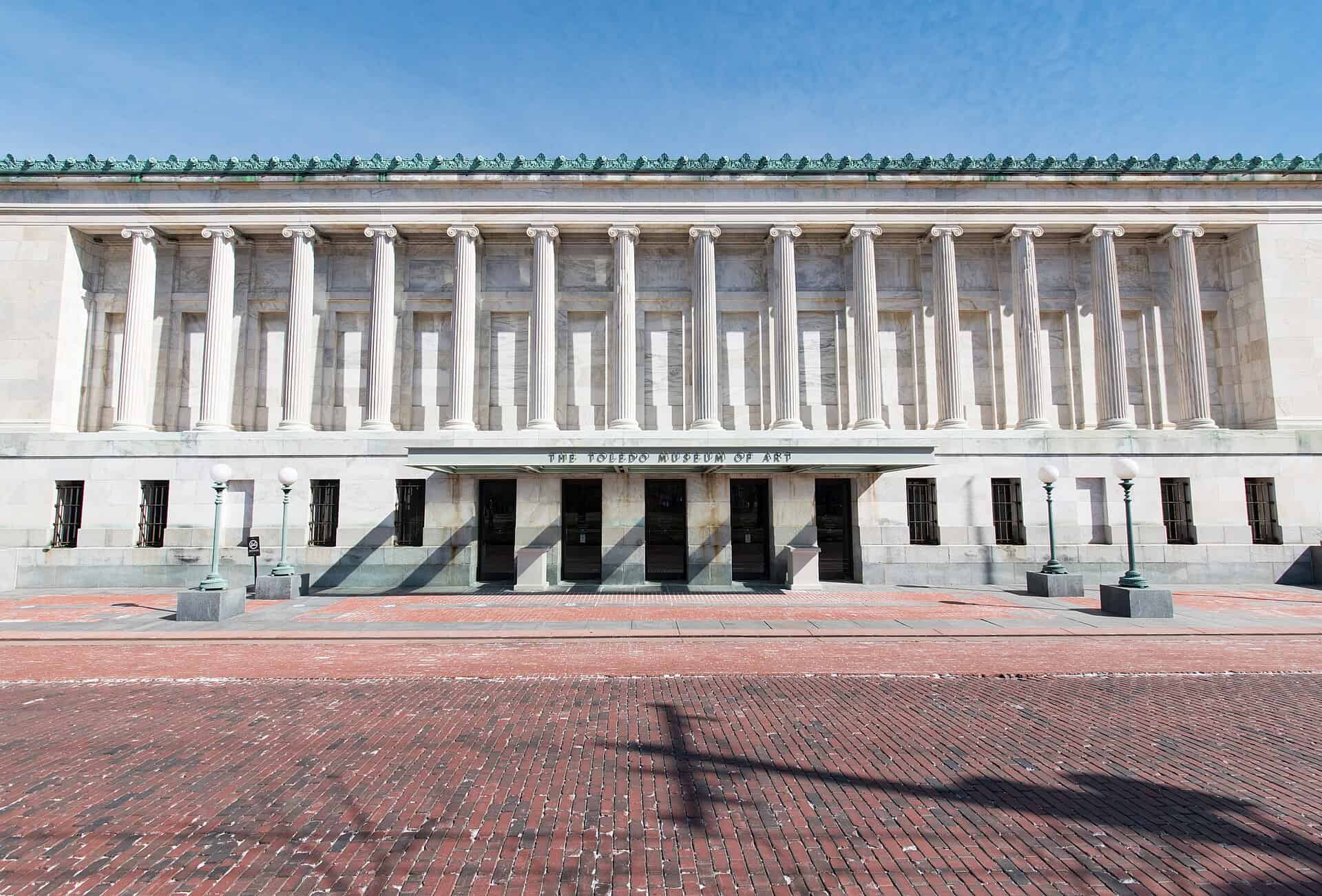 Colonnaded Greek Revival facade of the Toledo Museum of Art seen across its brick plaza