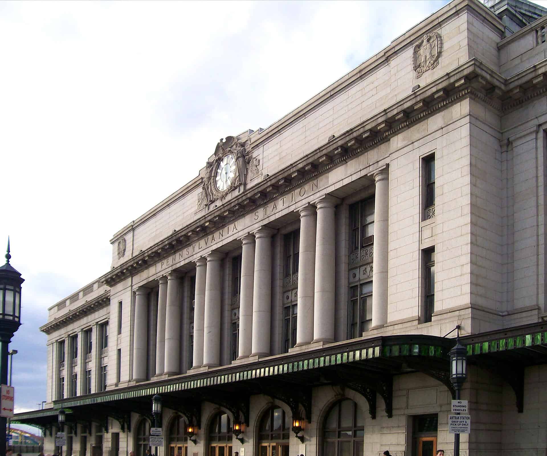 Colonnaded Charles Street facade of Baltimore Penn Station with the station clock above the entrance canopy
