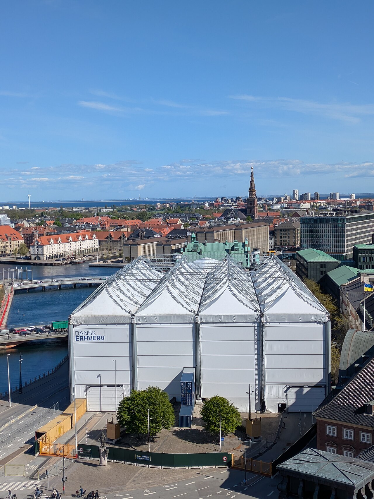 Børsen in Copenhagen enclosed in a white temporary weather shelter marked Dansk Erhverv during reconstruction, seen from above in May 2025
