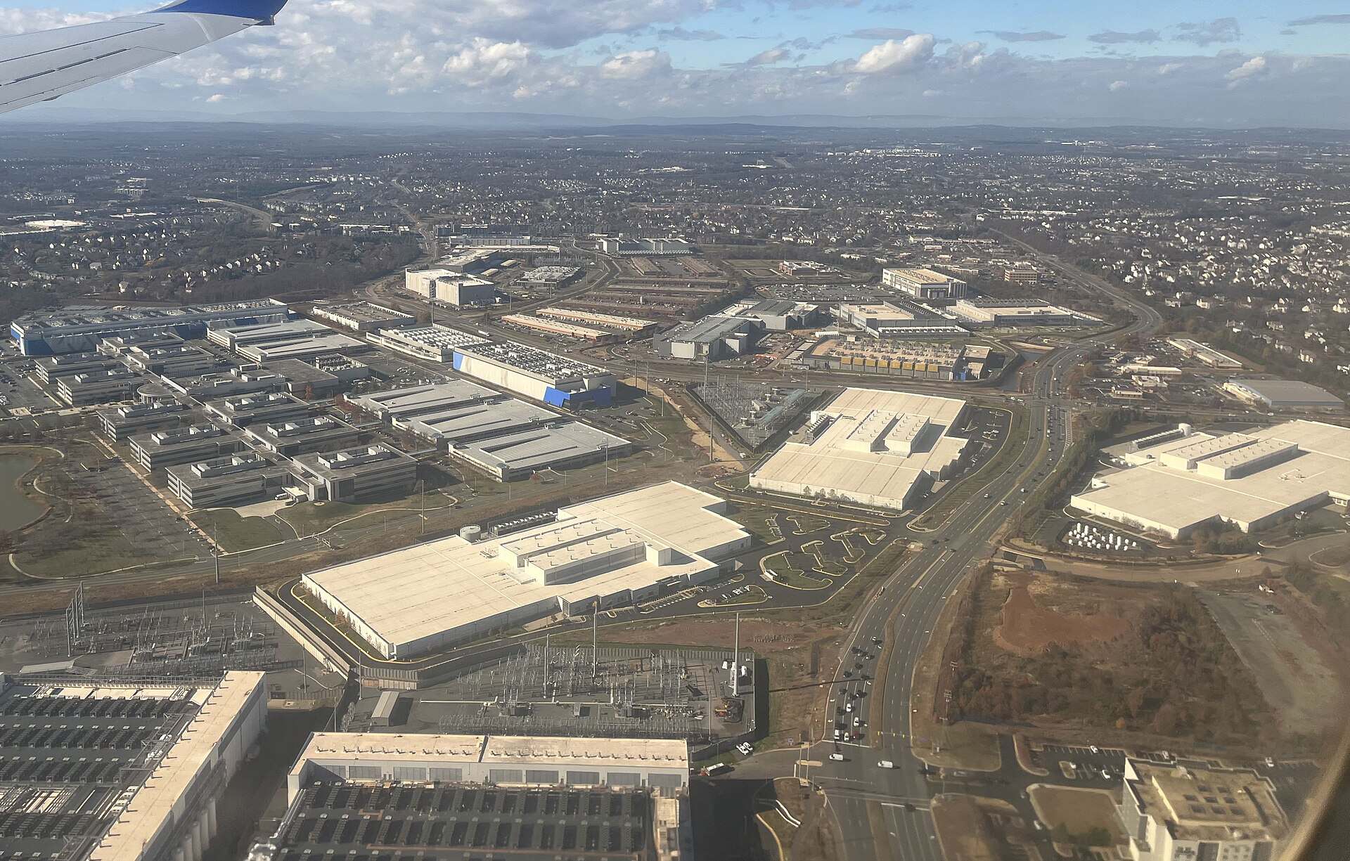 Aerial view of a dense cluster of data center buildings along a highway in Loudoun County, Virginia