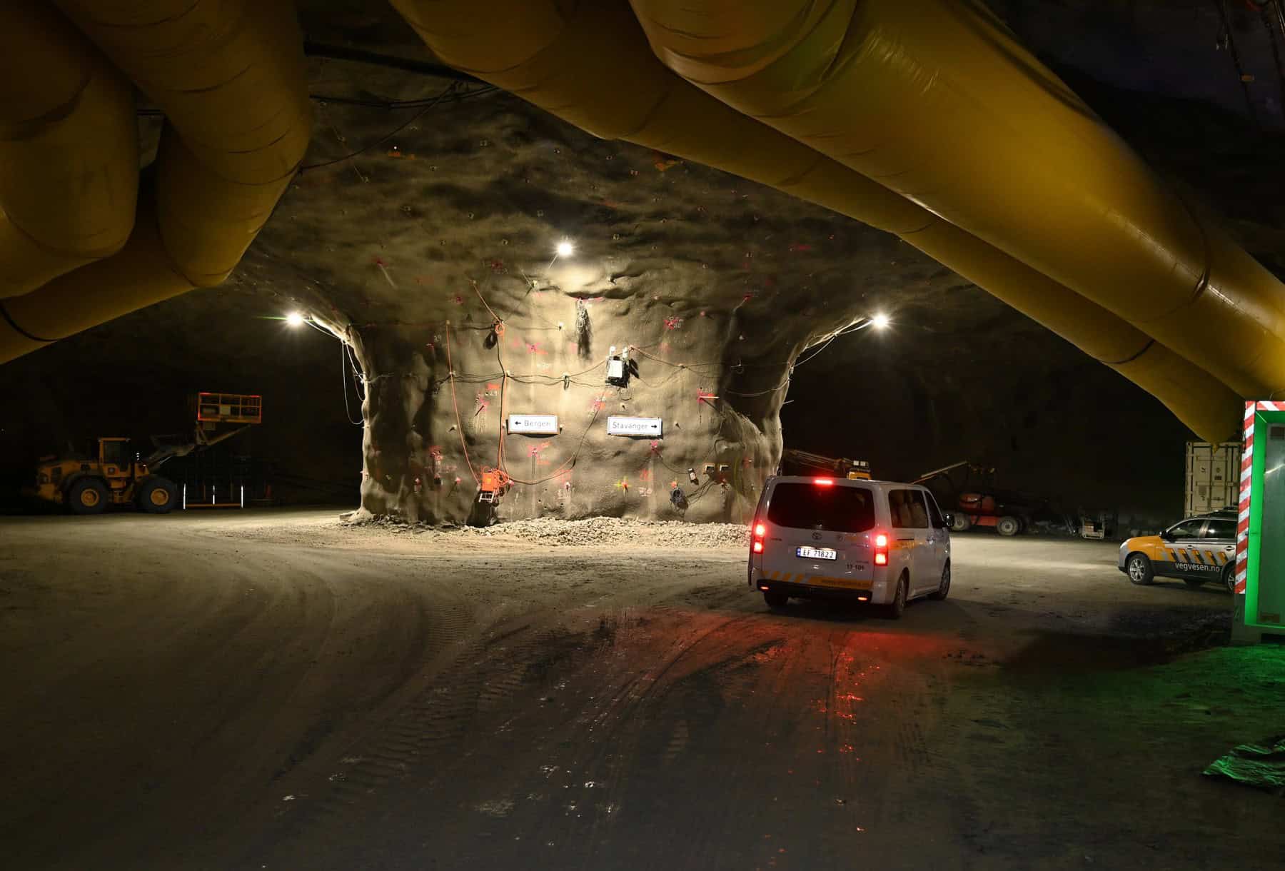 Excavated rock face and vehicles inside a Rogfast tunnel heading during an open day
