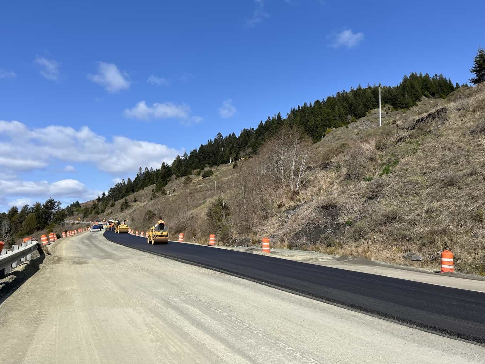 Paving crew laying asphalt on a highway widening project