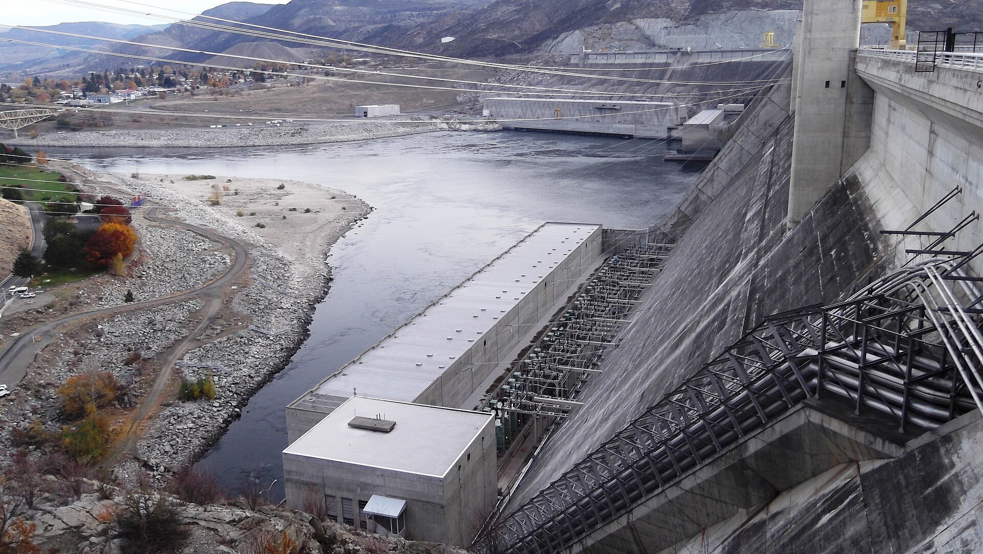 Projects Grand Coulee Dam's Third Power Plant powerhouse at the foot of the dam's forebay section on the Columbia River, with penstocks and transmission lines