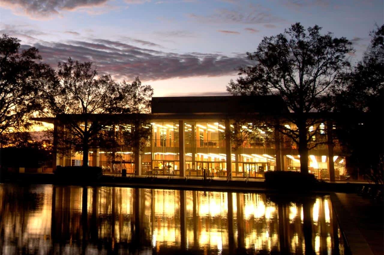 Thomas Cooper Library lit at dusk across its reflecting pool at the University of South Carolina