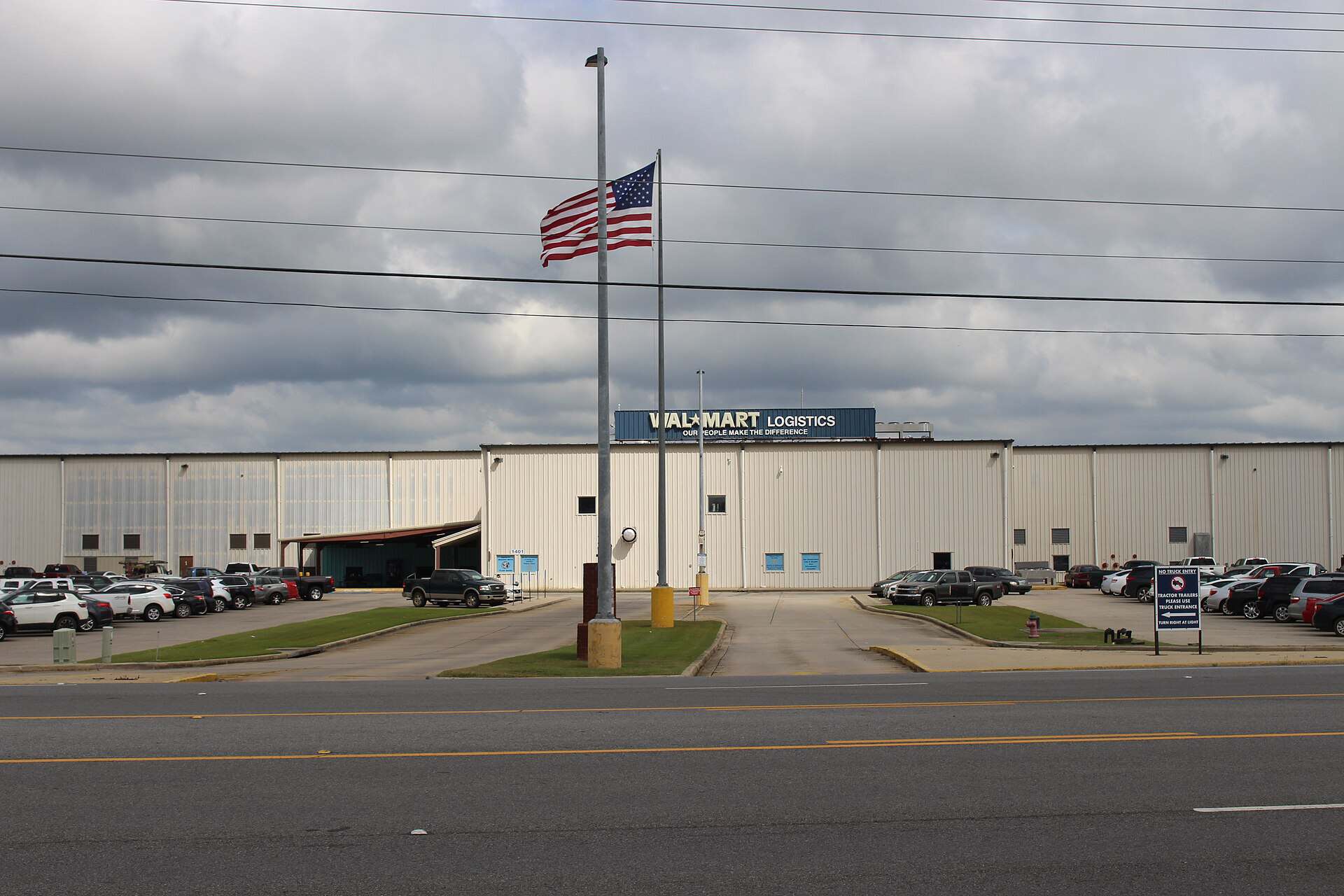 Exterior of a Walmart Logistics distribution center in Douglas, Georgia, with an employee parking lot in front
