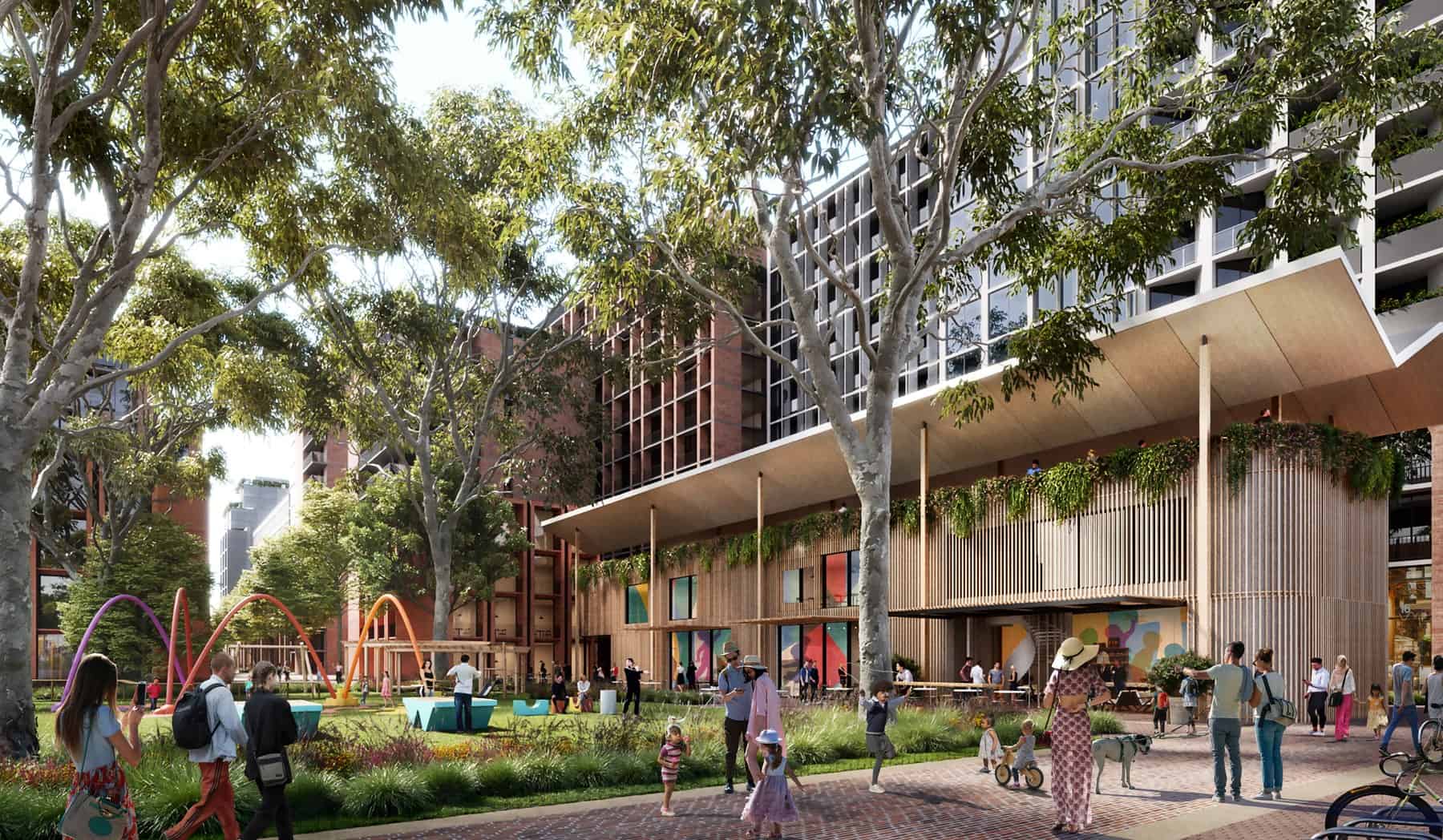 Street-level rendering of the Waterloo South redevelopment showing apartment buildings, mature trees and a public play space