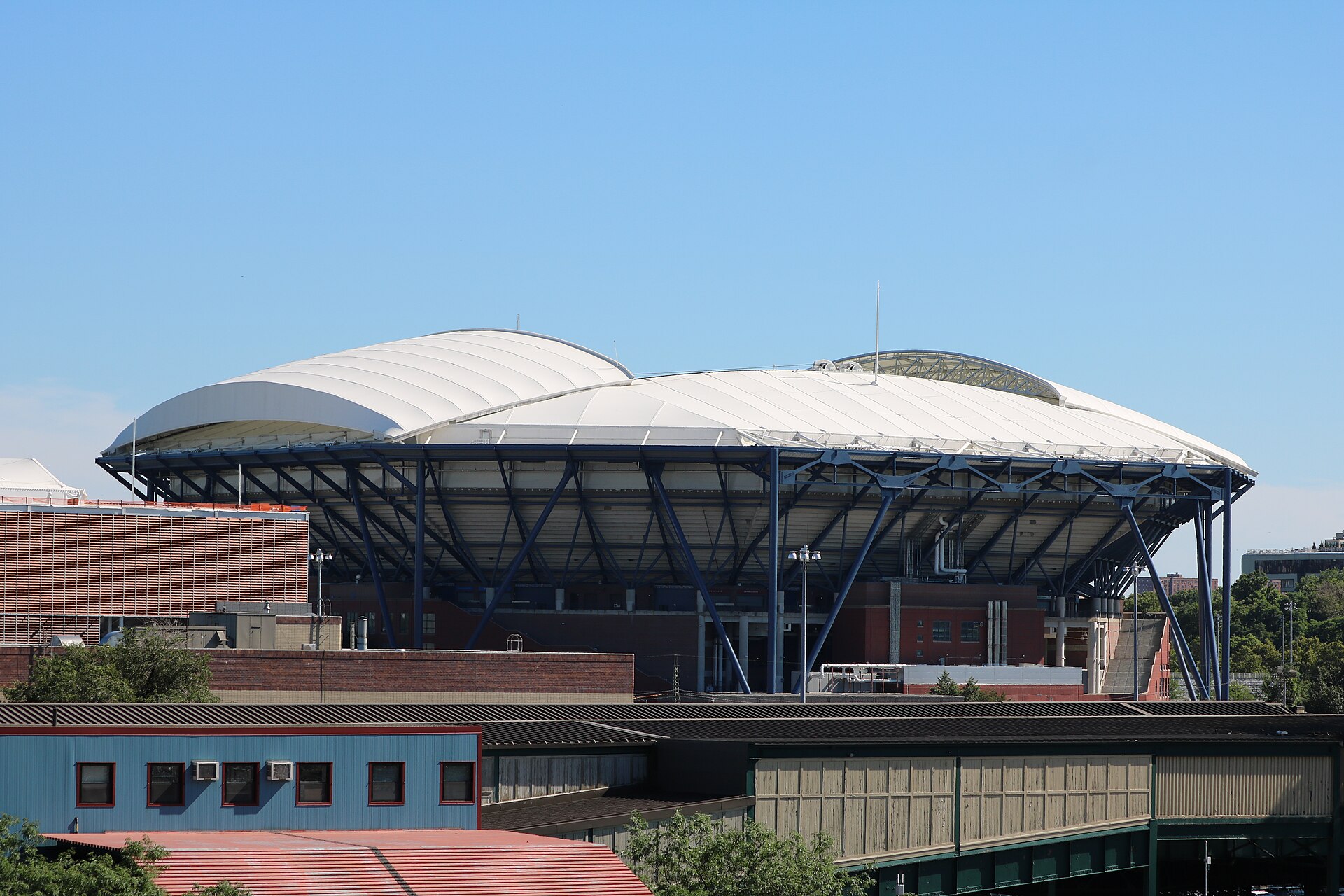 Projects Exterior of Arthur Ashe Stadium in Queens with its white retractable roof and blue steel supports, 2018