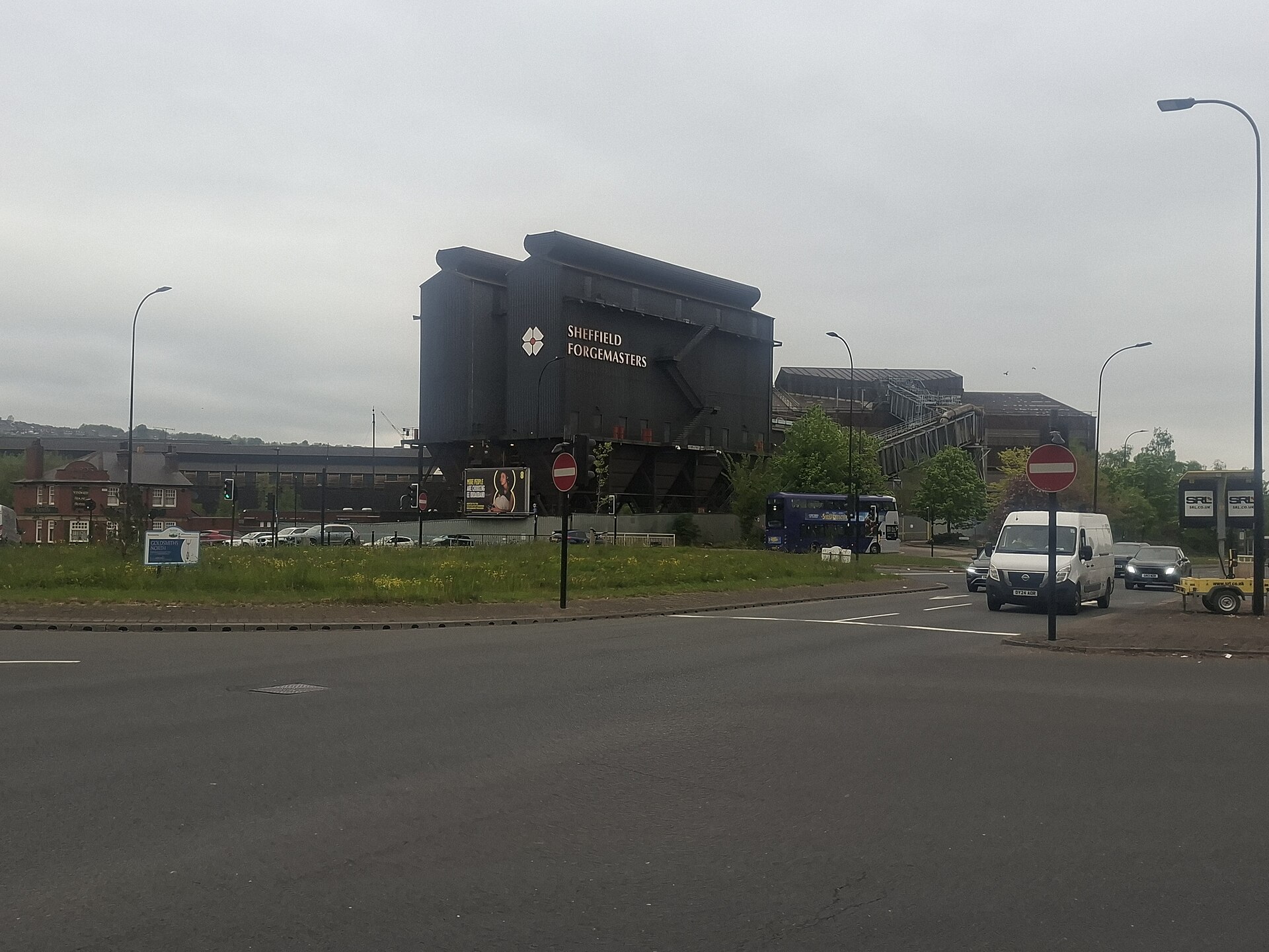 A dark-clad Sheffield Forgemasters plant building with the company name and logo, seen across a road junction in Sheffield in April 2026